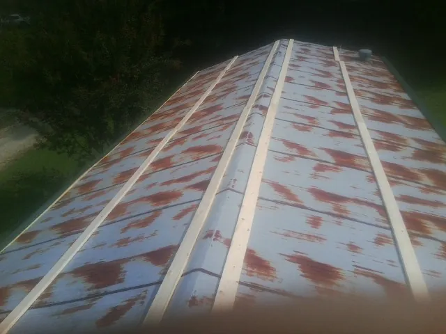 Rusted metal roof panels with new wood purlins before replacement — Storm Damage Roof Repair in Monson by Roofing Brothers