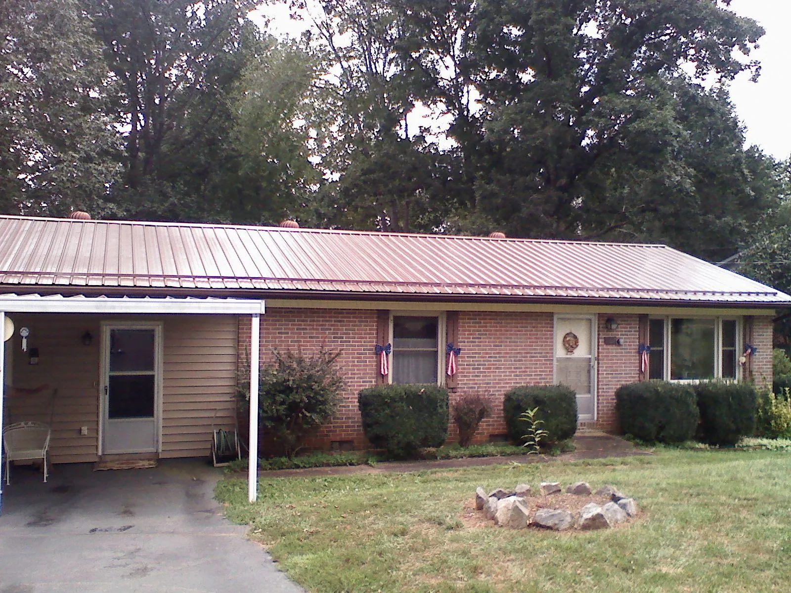Bronze metal roof and carport on a brick ranch home — Roof Repair work by our crew in Monson